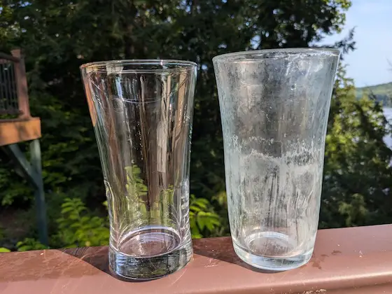 etched drinking glass next to a new clear one